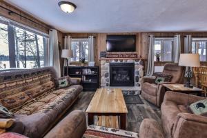 a living room with a couch and a fireplace at Our Lakeside Legacy in Saint Germain