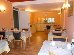 a restaurant with white tables and chairs and a counter at Swiss Lodge Nassa Garni in Lugano