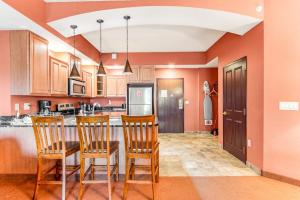 a kitchen with orange walls and wooden cabinets and chairs at Chula Vista 2517 & 2519 in Wisconsin Dells +36 photos