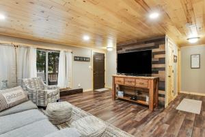 a living room with a couch and a flat screen tv at The Lazy Bear in Saint Germain