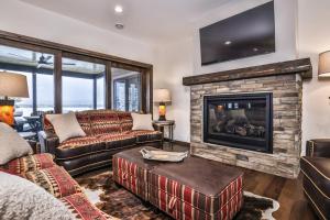 a living room with a couch and a fireplace at Endless Summer in Sayner