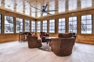 a living room with chairs and a ceiling fan at Endless Summer in Sayner