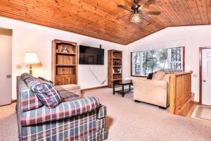 a living room with two couches and a flat screen tv at Watermelon Retreat in Three Lakes