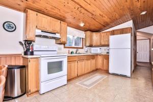 a kitchen with white appliances and wooden cabinets at Watermelon Retreat in Three Lakes