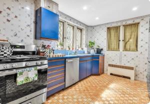a kitchen with blue cabinets and a stove at The Mayfair Castle in Buffalo