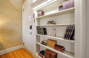 a book shelf filled with books in a hallway at The Mayfair Castle in Buffalo