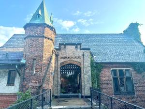 an old brick building with a gate and a tower at The Mayfair Castle in Buffalo