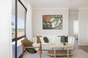 a living room with a white couch and a table at Coastal Bliss in Lemon Tree Passage +10 photos