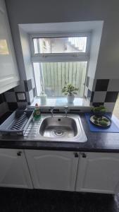 a kitchen with a sink and a window at Easy Stay Jerviston in Mossend