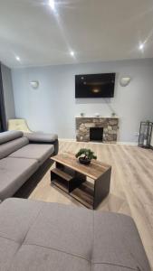 a living room with a couch and a fireplace at Easy Stay Jerviston in Mossend