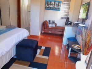a bedroom with a bed and a couch and a chair at EcoGreen B&B On 222 Botha in Northam +11 photos