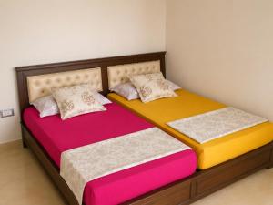 two beds in a room with colorful sheets at Seaside Mediterranean Duplex in Kelibia