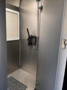 a shower with a glass door in a bathroom at One Life Glamping Caravan Rawson in Rawson