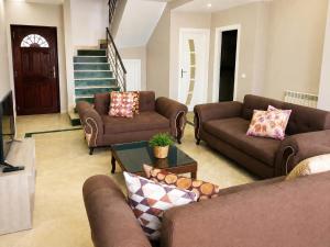 a living room with two couches and a tv at Seaside Mediterranean Duplex in Kelibia
