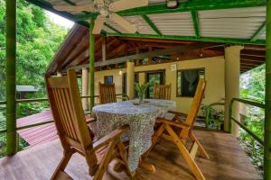 a dining room with a table and chairs on a deck at Casa Selva in Dominicalito