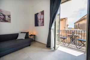 a living room with a couch and a balcony at Demetra in Noto