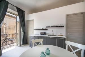 a kitchen with a table and a kitchen with a balcony at Demetra in Noto