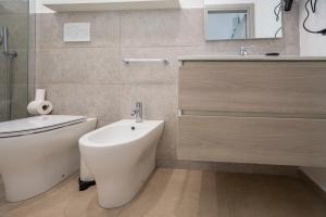 a bathroom with a toilet and a sink and a tub at Demetra in Noto +8 photos