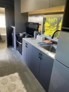 an rv kitchen with a sink and a window at One Life Glamping Caravan Rawson in Rawson