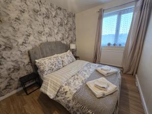a bedroom with a bed with two towels on it at Relax Stay 2 Bedroom in Theale +6 photos