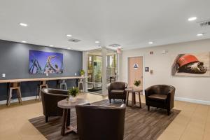 a waiting room with chairs and tables and a tv at Good Nite Inn Buena Park in Buena Park