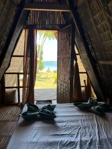 a bedroom with a bed with a view of the ocean at Lumindas Beach Resort in Sabang