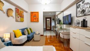 a living room with a blue couch and a table at The Mosaic Tower Luxury Boutique Studio,Pool and Gym Fast Wifi in Manila