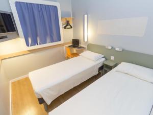 a hospital room with two beds and a window at ibis budget Blumenau in Blumenau +70 photos