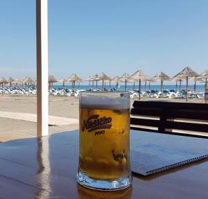 a glass of beer sitting on a table near the beach at Apartaments A4 in Ulcinj