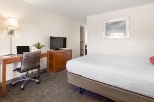 a hotel room with a bed and a desk with a computer at Good Nite Inn Camarillo in Camarillo