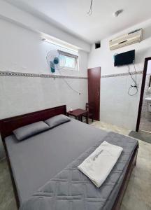 a bedroom with a large bed with a fan at Nhà Nghỉ Hoa Lan2 in Buon Ma Thuot