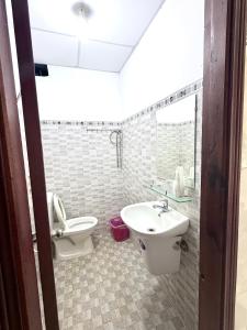 a bathroom with a toilet and a sink at Nhà Nghỉ Hoa Lan2 in Buon Ma Thuot