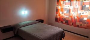 a bedroom with a bed and a painting on the wall at Casa para 10 personas A 10 MIN CENTRO DE ORIZABA in Orizaba