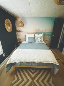 a bedroom with a bed with a painting on the wall at The Get Away Haven in Stockbridge