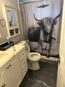 a bathroom with a cow on the shower curtain at The Get Away Haven in Stockbridge