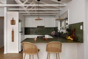 a kitchen with a counter and two chairs in it at Wondervale in Burrawang