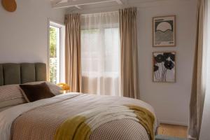 a bedroom with a large bed and a window at Wondervale in Burrawang
