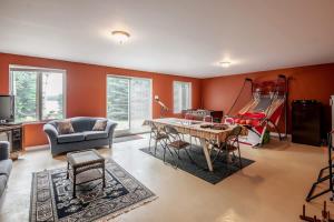 a living room with orange walls and a table and chairs at Le Chaleureux du Lac Blanc - Nominingue in Nominingue