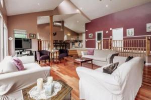 a living room with white furniture and a red wall at Le Chaleureux du Lac Blanc - Nominingue in Nominingue