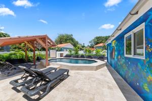 a swimming pool with two lounge chairs next to a house at Caribe CBW in Willemstad