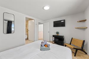a white bedroom with a bed and a chair at Caribe CBW in Willemstad