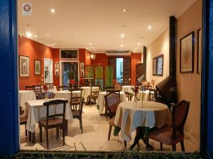 a restaurant with tables and chairs with white table cloth at Cinque Terre Pousada & Bistrô in Rio de Janeiro