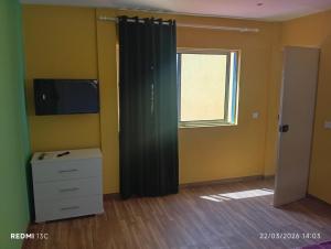 a room with a window and a curtain and a dresser at Casa Chez Zoe in Salamansa