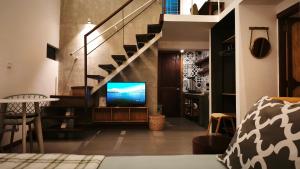 a living room with a tv and a staircase at Cozy & Spacious 2BR Private House in Siem Reap