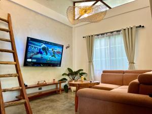 a living room with a couch and a tv on the wall at Farm Village in San Juan