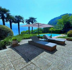 eine Terrasse mit zwei Sofas und einem Sonnenschirm in der Unterkunft Villa Maria in Onno