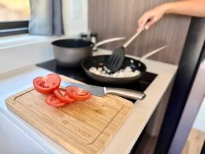 a person cooking on a stove with tomatoes on a cutting board at Mountain View in Orderville
