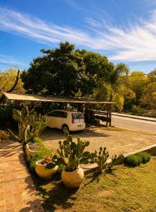 a car parked in front of a house with cactus at Ohana Apartments (solo familias) in Villa Carlos Paz