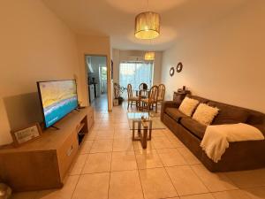 a living room with a couch and a flat screen tv at En el Corazón de la Quinta. in Villa Marini