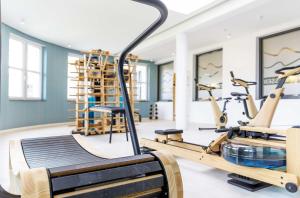 a gym with exercise bikes and treadmills at Großer Strandkorb - Stilvolles Ferienapartment in der Alten Seefahrtsschule in Wustrow